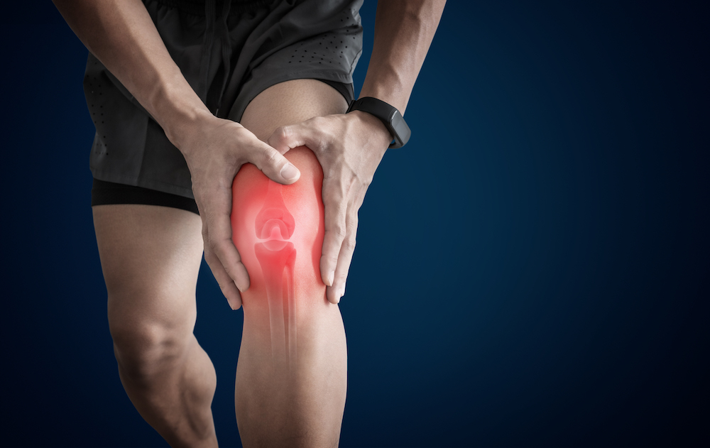 man having a knee pain from overuse injury