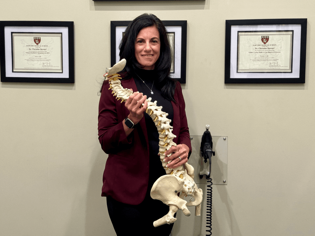 Dr. Christine Stewart, holding a full spine model